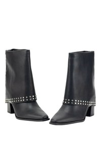 Botas de tobillo de cuero negro con un diseño holgado, puntas cuadradas y una banda de acentos con tachuelas alrededor de la parte media. Tacón bloque para mayor estabilidad.