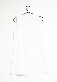 Robe blanche sans manches en tissu léger, avec un col rond, un détail plissé à l'arrière et un ourlet droit.