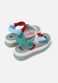 Värikad platåsandaler med en teal fotbädd, röda och rosa remmar samt en vit upphöjd sula. Texturerat material för extra komfort.