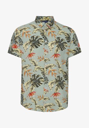 Šviesiai žalia trumpomis rankovėmis marškinėlių chemise, papuošta juodais, oranžiniais ir geltonais tropiniais palmės lapais. Klasikinio apykaklės dizainas.