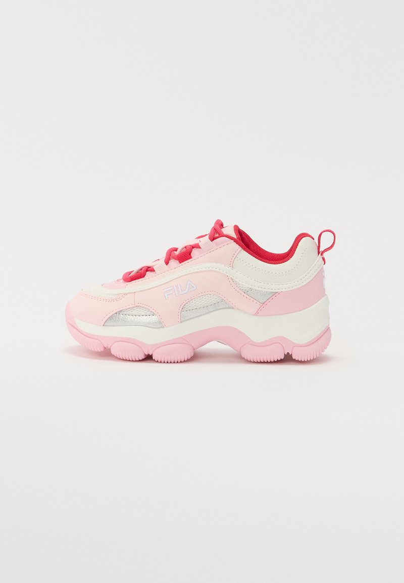 Rózsaszín és fehér sportcipő, texturált felsőrésszel, hálós részletekkel, ezüst díszítéssel és vastag rózsaszín talppal. Piros fűzőkkel és saroktabbal rendelkezik.