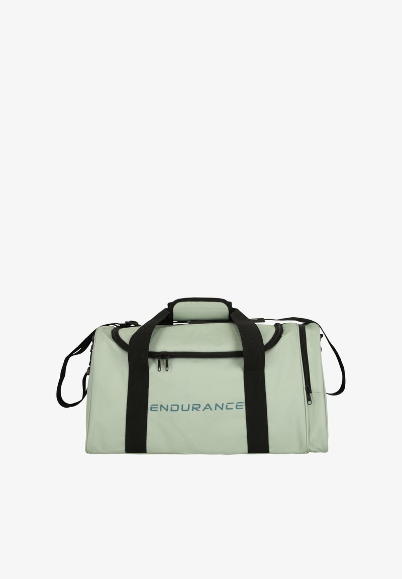 Sac de sport en matériau vert clair avec des accents noirs, doté de deux poignées, d'une sangle d'épaule et d'une poche zippée à l'avant. "ENDURANCE" imprimé sur le côté.