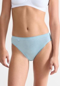 Lyseblåt bomuldsbikiniundertøj med glat tekstur, en lav talje og delikat bølget kant langs taljebåndet og benåbningerne.