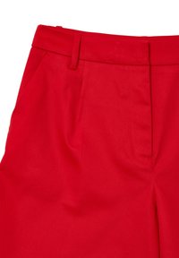 Pantaloni rossi a vita alta con passanti per cintura, tasche laterali e chiusura frontale nascosta.