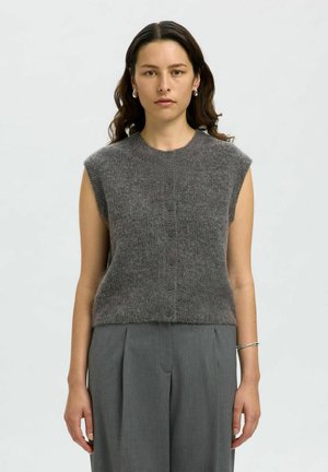 Gray knitted sleeveless vest with a round neckline and front buttons. Soft texture, slightly loose fit, paired with gray trousers.