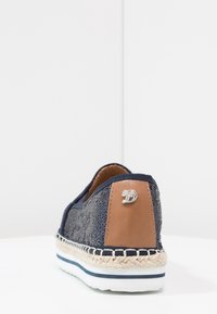Ballerine marine à enfiler avec un tissu texturé, des accents en cuir marron, une semelle intermédiaire en jute de style espadrille, une semelle en caoutchouc blanc et un détail de logo en métal.