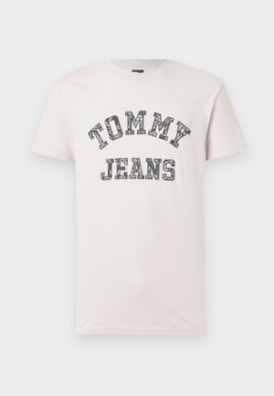 Jasnoróżowa bawełniana koszulka z czarnym wzorem kwiatowym i napisem "TOMMY JEANS", prosty okrągły dekolt i krótkie rękawy.