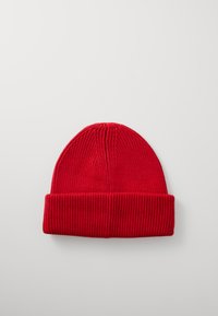 Red knit beanie with a ribbed texture, featuring a folded cuff and a rounded top. Made from soft material for warmth.