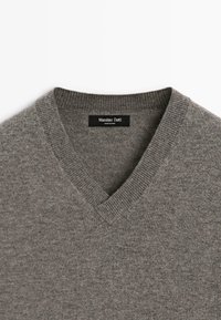 Grijze V-hals gebreide trui met ribgebreide kraag en Massimo Dutti-label aan de hals.