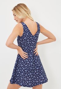 Vestido azul marino con estampado de paisley, con cuerpo ajustado y falda acampanada. Diseño de espalda en forma de V y tirantes anchos. Textura de tela suave.