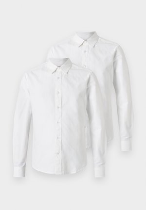 Divas garu piedurkņu baltas kokvilnas krekli, ar pogu priekšpusi, norādītu apkakli un taisnām piedurknēm. Gluda tekstūra, bez rakstiem.