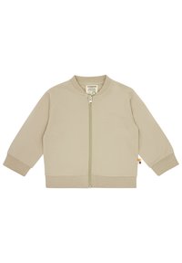 Khakifarbene Zip-Jacke mit runder Kragen, langen Ärmeln, gerippten Bündchen und Saum sowie einem grünen Reißverschluss. Mit einem seitlichen Etikett in farblichen Akzenten.