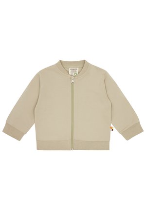 Khakifarbene Zip-Jacke mit runder Kragen, langen Ärmeln, gerippten Bündchen und Saum sowie einem grünen Reißverschluss. Mit einem seitlichen Etikett in farblichen Akzenten.