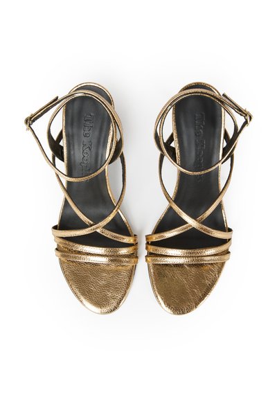 Pair of metallic gold open-toe sandals with crisscross ankle straps and black insoles, shown from above on a white background.