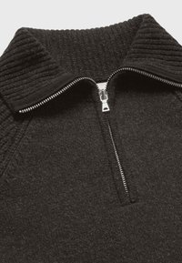 Maglione nero con cerniera a metà, colletto a coste, tessuto testurizzato e dettagli in metallo argentato sulla cerniera. Design a collo alto per calore e stile.