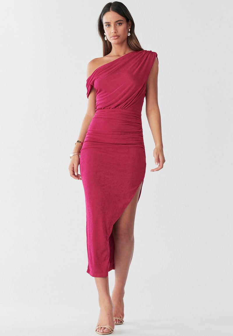 Fuksija haljina bez ramena s naboranim dizajnom, teksturiranim tkaninom, bočnim prorezom, nabranim strukom i rubom u duljini gležnja. Prozirne sandale na visoku petu.