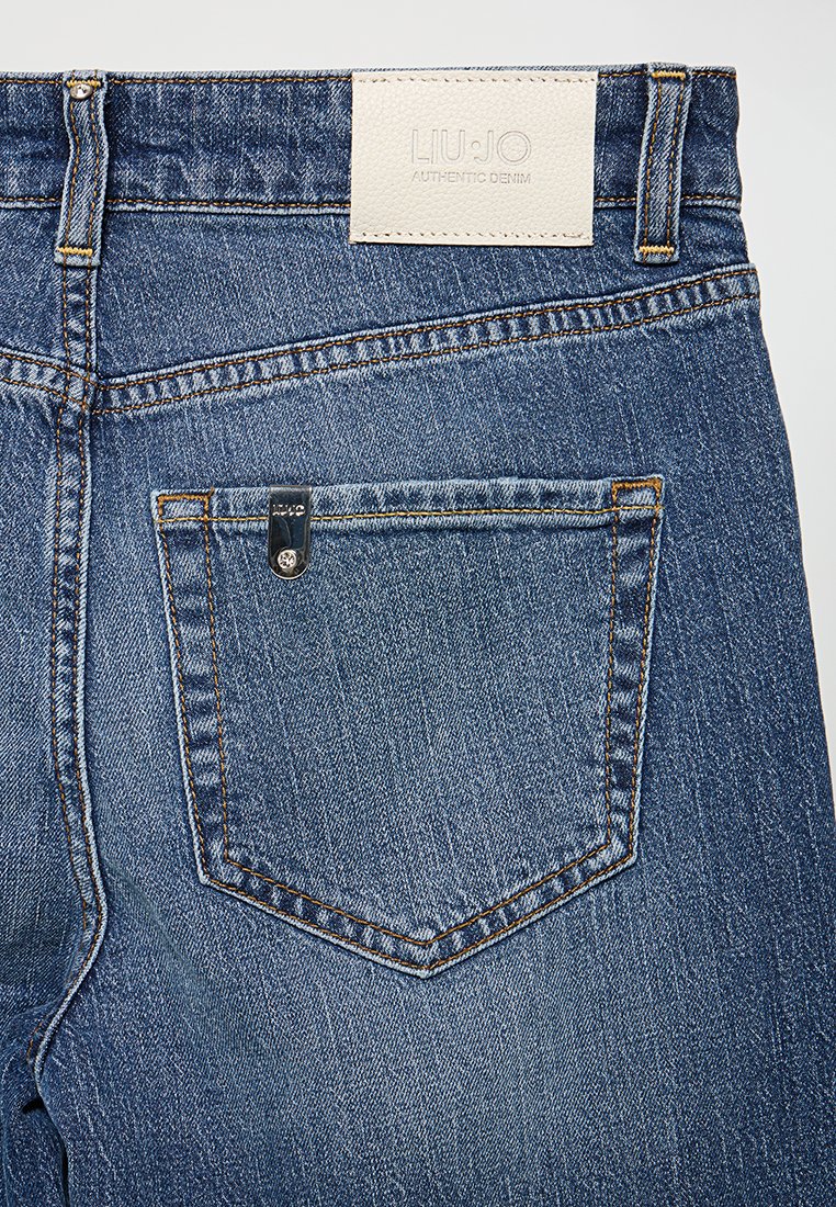Jeans in denim blu scuro con una finitura testurizzata. Le caratteristiche includono una tasca posteriore quadrata, etichetta in pelle con il testo "LIU JO" e cuciture a contrasto.