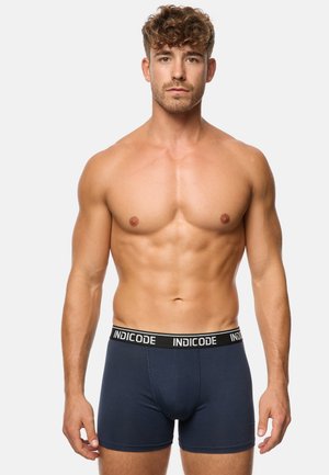 Blaue Boxershorts mit schwarzem Bund, der das "INDICODE"-Logo trägt. Aus weichem Stoff gefertigt, bieten sie ein enges Design und eine glatte Textur.