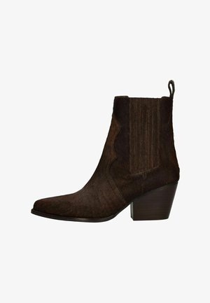 Donkerbruine cowboylaars tot halverwege de kuit met een puntige neus, blokhak, elastische zijpanelen en een lusje aan de achterkant.