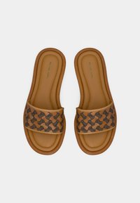 Sandales à semelle plate marron avec une lanière à motif dans des nuances de marron et de noir, avec une semelle intérieure matelassée et des coutures visibles autour du bord.