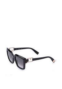 Lunettes de soleil carrées noires oversize avec verres foncés dégradés et accents métalliques dorés sur les branches, sur fond blanc.