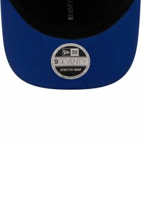 Niebieska czapka z czarnym daszkiem, z okrągłą białą metką oznaczoną "9SEVENTY STRETCH-SNAP" od New Era, z widocznymi detalami przeszycia.