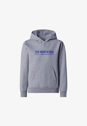 Zbliżenie osoby noszącej szarą bluzę z kapturem z napisem "THE NORTH FACE Berkeley, CA 1966 Never Stop Exploring" w niebieskim kolorze.