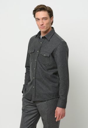 Camisa de botones gris hecha de tela texturizada, con dos bolsillos en el pecho, botones de hardware plateado y un ajuste relajado.