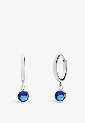Silver hoop earrings featuring a blue faceted crystal pendant, smooth metal surface, and a hanging design with a simple clasp closure.