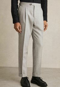 Light gray pleated trousers with a subtle checked pattern, featuring a straight-leg design and cuffed hems, paired with black shoes.