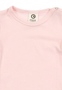 Růžový žebrovaný bavlněný dětský top s kulatým výstřihem a zapínáním na druky na rameni. Má jemnou strukturu a jednoduchý design.