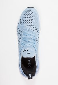 Light blue athletic shoe with mesh upper, black accents, round toe, and white sole. Features laces and branding on the tongue and heel.