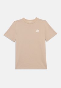 Beżowa koszulka z krótkim rękawem wykonana z fakturowanej tkaniny, z prążkowanym wzorem i białym logo na lewej piersi.