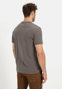 Graues T-Shirt mit kurzen Ärmeln und rundem Ausschnitt, aus weichem Baumwollstoff gefertigt, mit einem schlichten und klaren Design. Lässige Passform, ohne Muster.