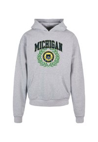 Szürke kapucnis pulóver, elülső zsebbel, húzózsinórral ellátott kapucnival és "MICHIGAN" felirattal egy kör alakú Michigan Egyetem embléma felett, amely babérlevelet ábrázol.