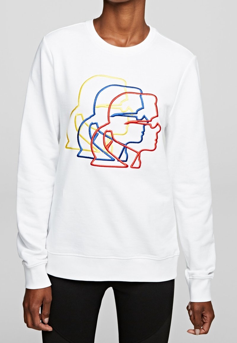 Sudadera blanca con contornos de rostros bordados en multicolor en rojo, azul y amarillo. Tela suave con puños y dobladillo de canalé.