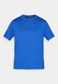 Tricou bleu cu mâneci scurte, fabricat dintr-un material ușor; prezintă un logo Jordan negru pe piept. Decolteu tip crew și textură netedă.