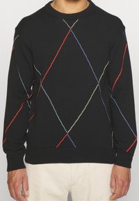 Černý svetr s vroubkovaným kulatým výstřihem. Obsahuje diamantové vícestínové prošívání v červené, modré a žluté barvě. Texturovaná tkanina.