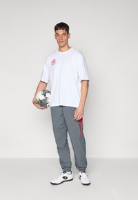 Umbro RELAXED TRACK PANT - Trainingsbroek - iron gate/red dahlia/brilliant white