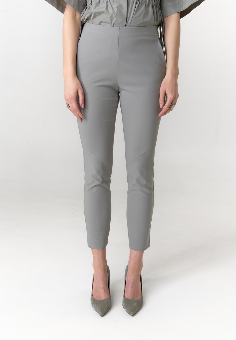 Grijze slim-fit broek met een gladde textuur, taps toelopende pijpen en enkellengte, gecombineerd met puntige grijze hakken.