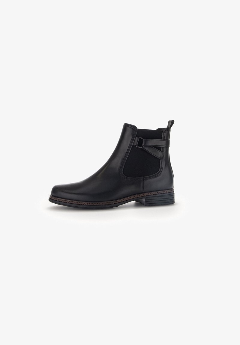 Bottine noire en cuir avec des côtés élastiques, un talon empilé bas et une lanière décorative avec boucle sur le côté extérieur.