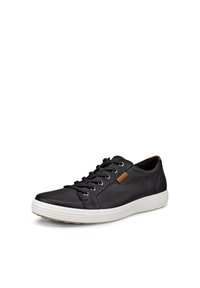 Sneaker en cuir noir avec un bout arrondi, semelle en caoutchouc blanche et accent de logo marron contrastant sur le côté. Comprend des œillets métalliques et des lacets.