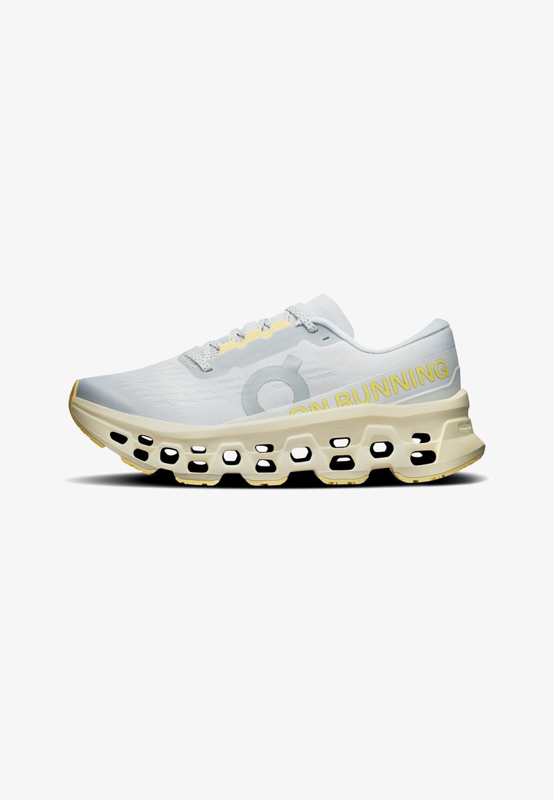 Chaussure de course blanche et jaune avec une semelle épaisse et perforée, et le texte « "ON RUNNING" » en jaune sur le côté, présentée de profil.
