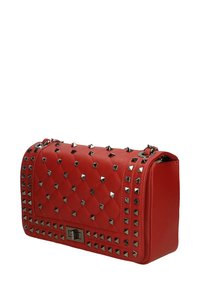 Borsa a tracolla rossa trapuntata con borchie a piramide metalliche, forma rettangolare, hardware in argento e chiusura a patta. Materiale in similpelle testurizzata.