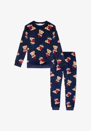 Conjunto de pijama de forro polar en color navy que presenta un patrón repetido de ositos de peluche con sombreros azules y bufandas rojas. Los pantalones tienen puños en los tobillos.