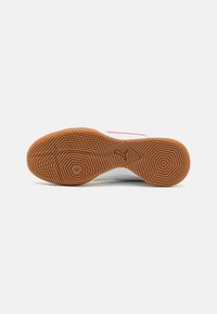 Semelle de sneaker blanche avec un motif texturé en caoutchouc gum. Présente un logo Puma et un design géométrique pour une meilleure traction.