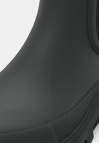 Botas de lluvia de goma negras con una parte superior suave, puntera redondeada, suela texturizada para un mejor agarre y paneles laterales elásticos para un fácil uso.