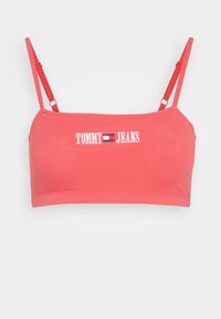 Korallefarbene, kurze Bralette aus weicher Baumwolle. Verfügt über verstellbare Träger und ein besticktes "TOMMY JEANS"-Logo mit Flaggen-Detail.