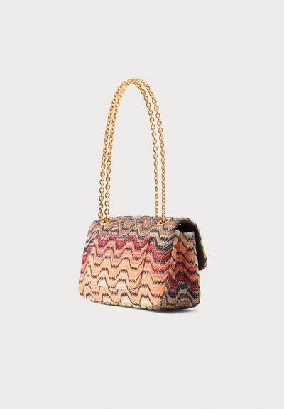 Sac à main rectangulaire en tissu zigzag multicolore avec longue bandoulière chaîne dorée sur fond uni.