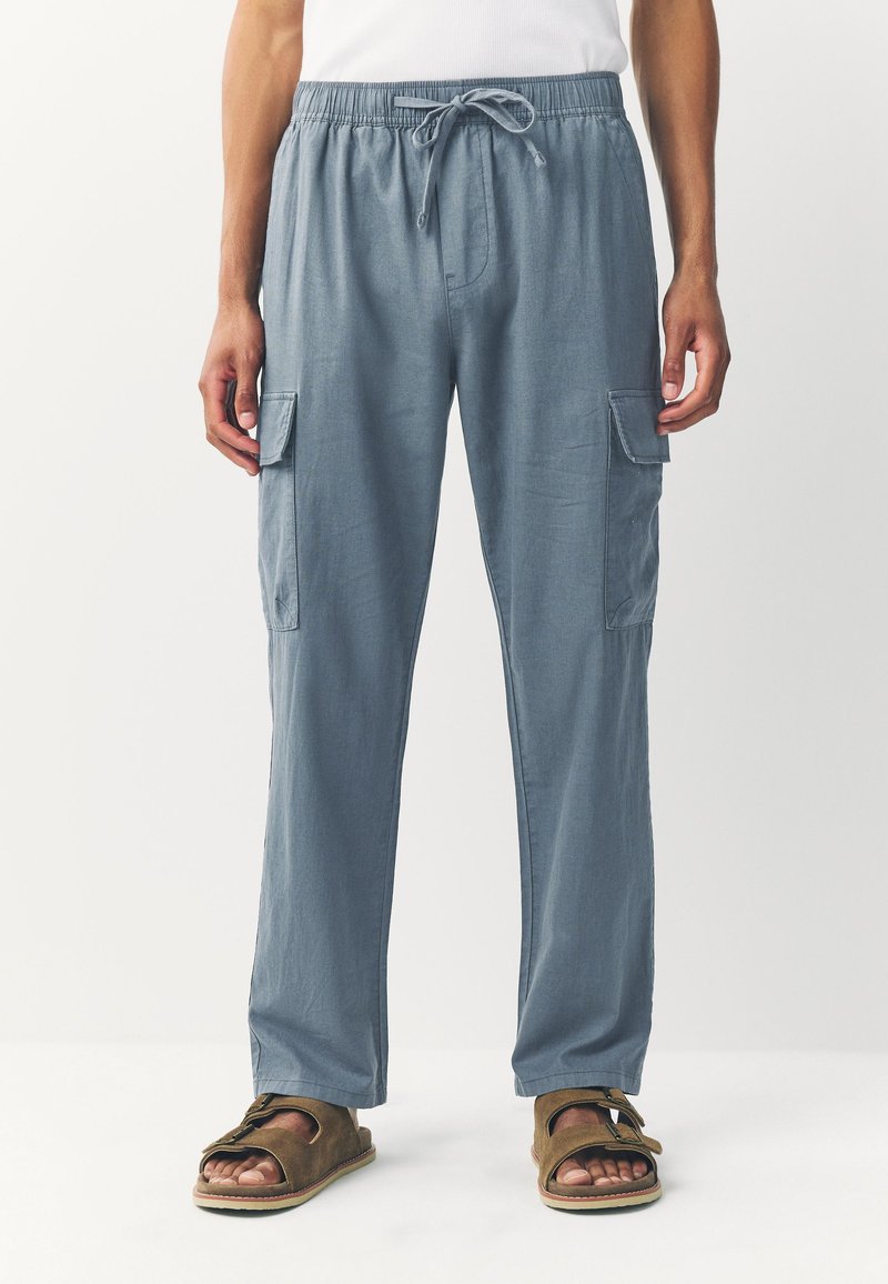 Light blue cargo pants with an elastic waistband and drawstring. Features side pockets and a straight leg design. Smooth, lightweight fabric.
